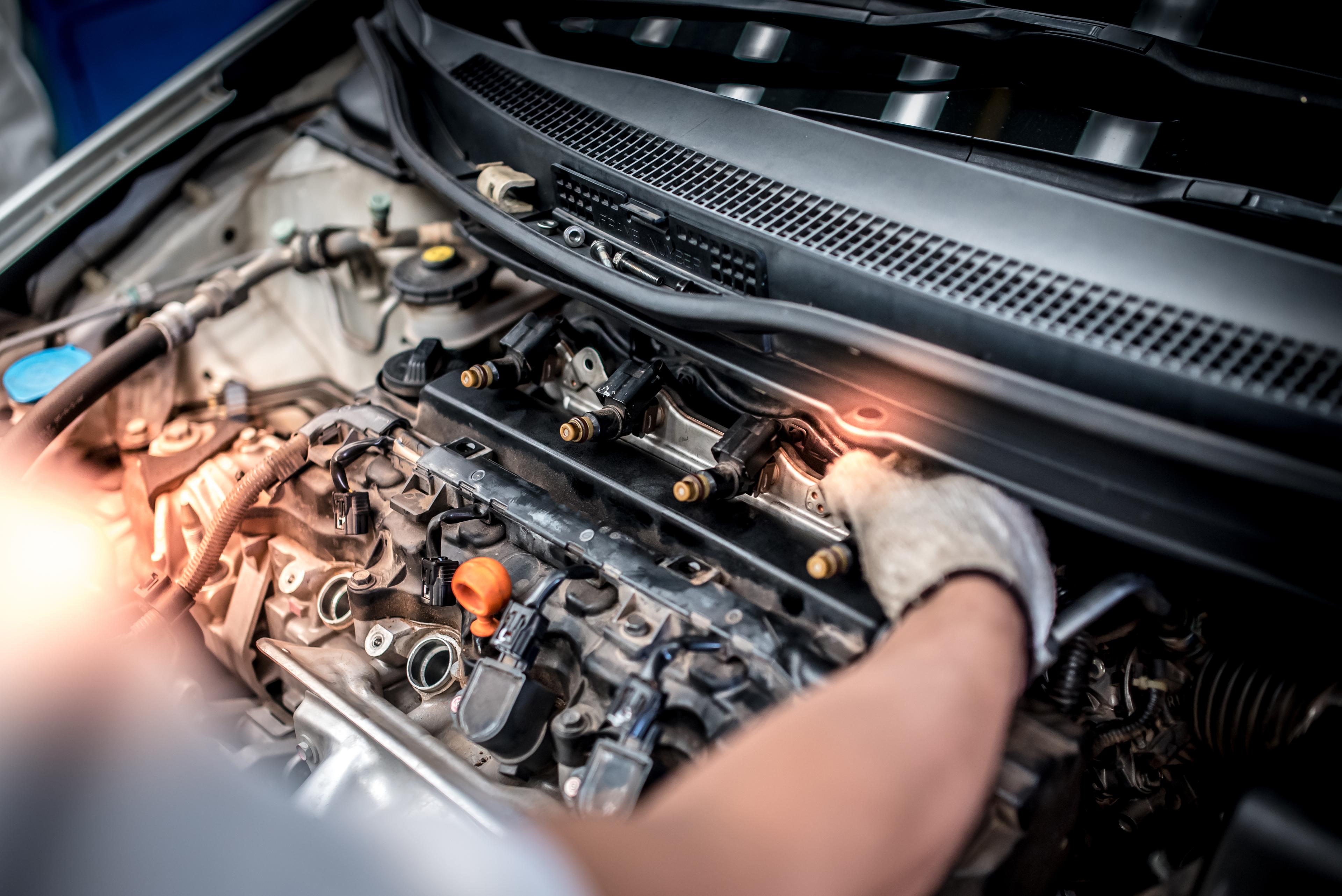Mechanic replaces a fuel injector