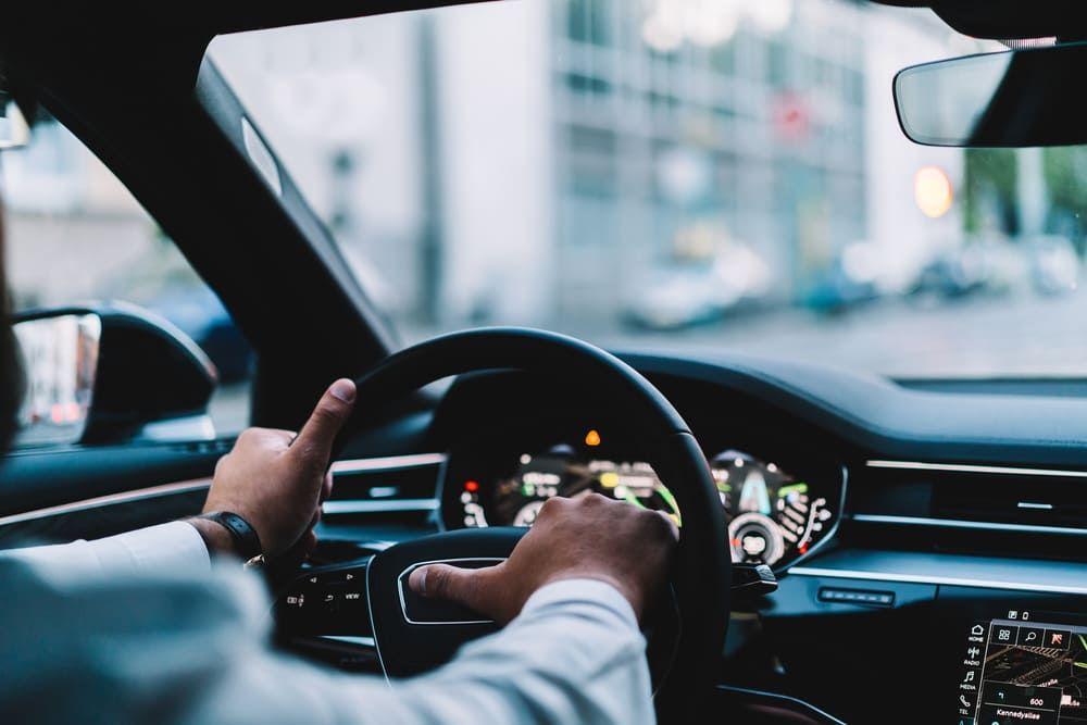 Man driving car in busy street