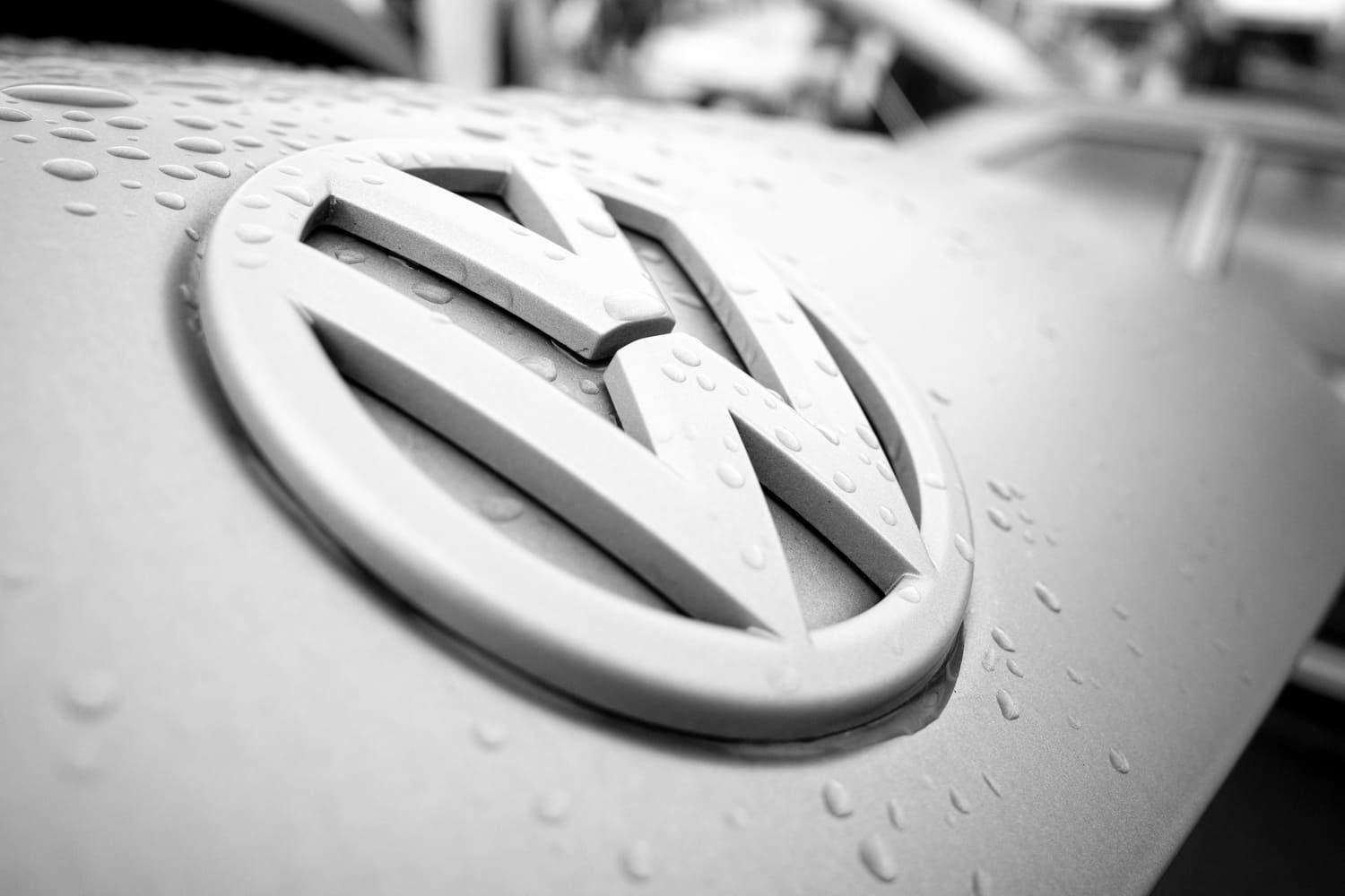 Silver VW badge on a wet car