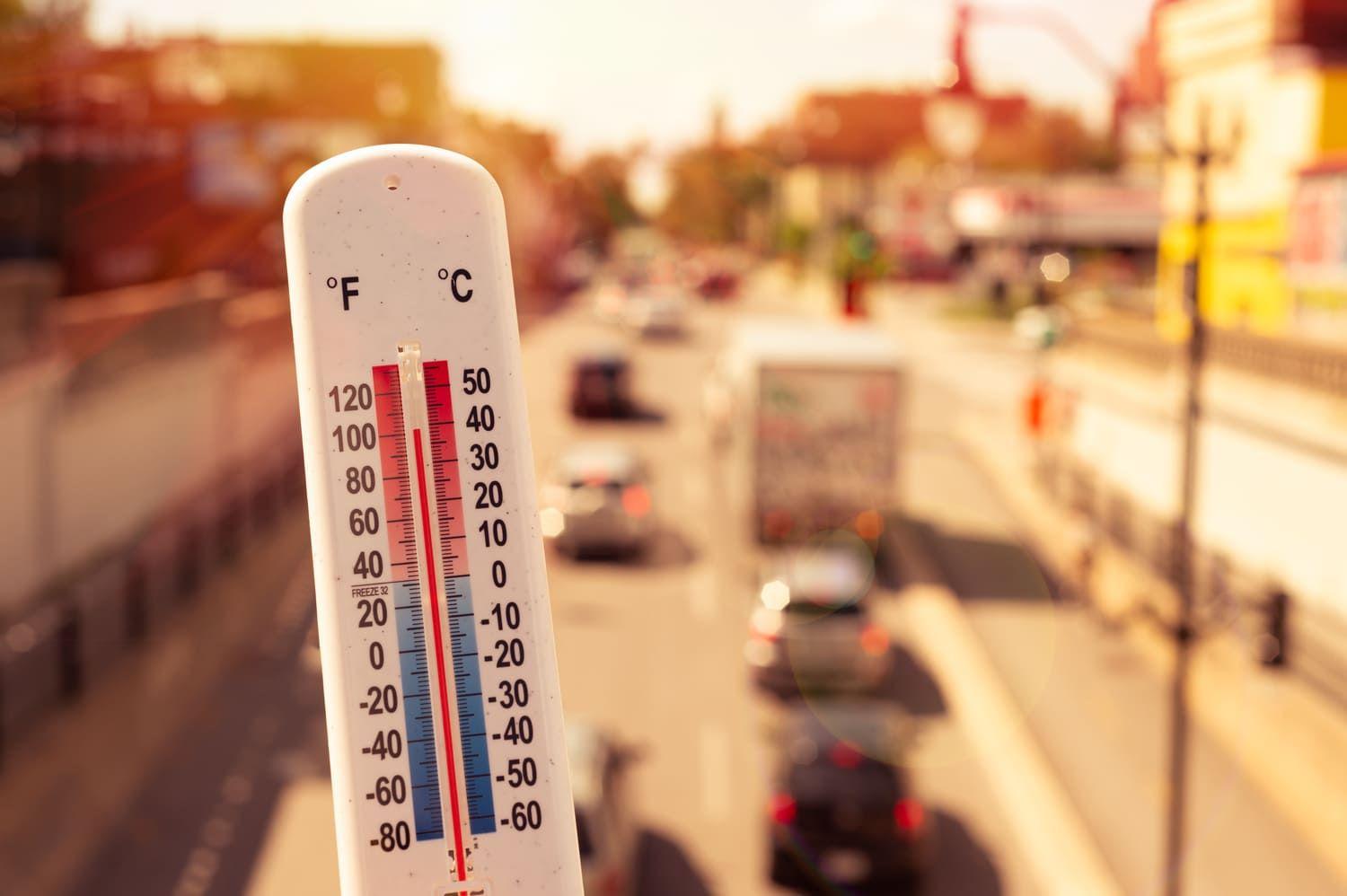 Hot thermometer held infront of a road